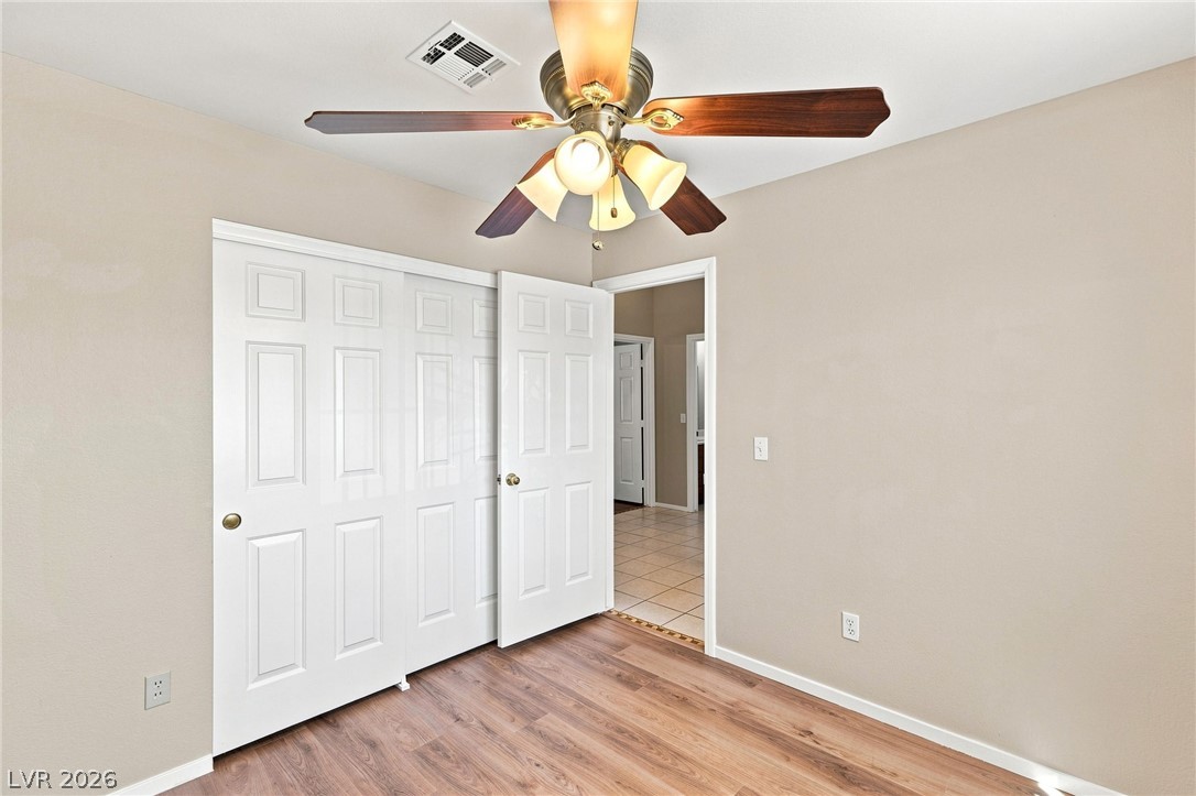 904 Shadowfax Road Henderson, NV 89015 - Photo 17 of 31 Warm wood floors and multi-panel doors define this charming bedroom.