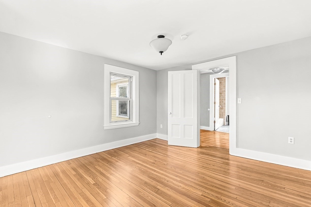53 Lake Street Winchester, MA 01890 - Photo 22 of 36 a view of an empty room with wooden floor and a window