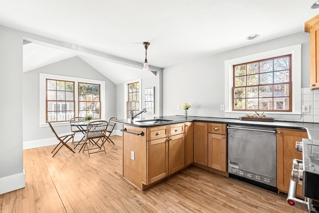 53 Lake Street Winchester, MA 01890 - Photo 10 of 36 a kitchen with stainless steel appliances granite countertop a stove a sink dishwasher a dining table and chairs with wooden floor