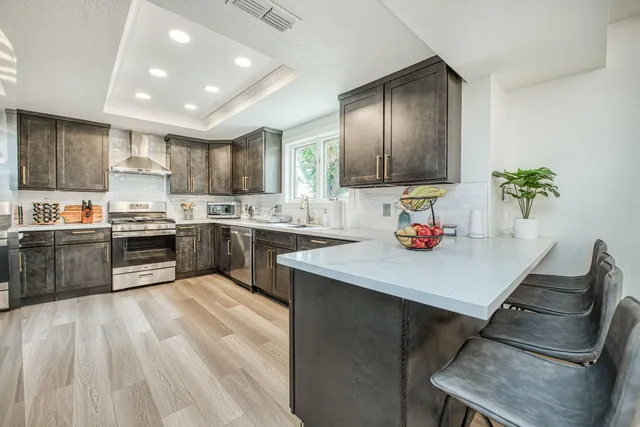 a kitchen with a sink stainless steel appliances and window