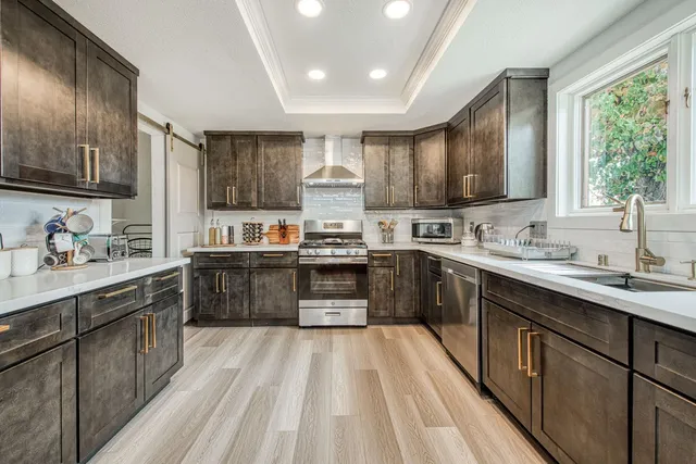 a kitchen with kitchen island granite countertop a sink counter top space stainless steel appliances and a window