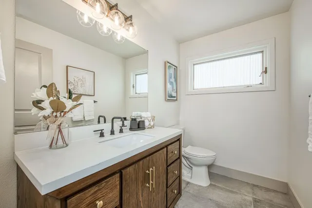 a bathroom with a sink a toilet and a mirror