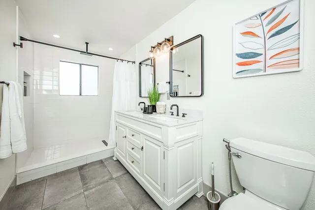 a bathroom with a double vanity sink toilet and shower