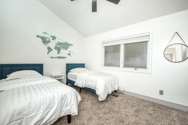 a bedroom with two beds and painting on the wall
