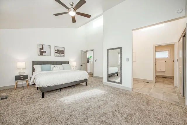 a spacious bedroom with a bed and ceiling fan