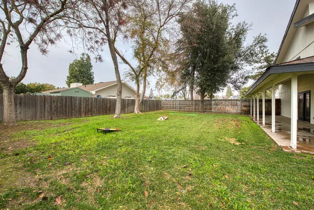 a view of a house with backyard and a tree
