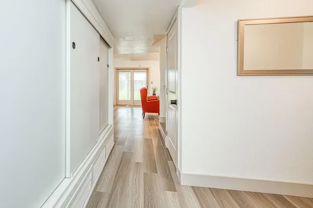 a view of a hallway with wooden floor and closet