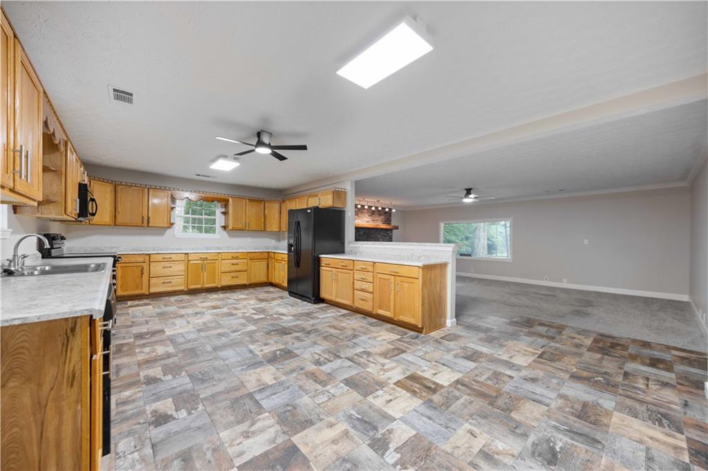 25 Gas Line Road Phenix City, AL 36870 - Photo 7 of 52 Kitchen featuring black appliances, a ceiling fan, light countertops, a peninsula, and crown molding