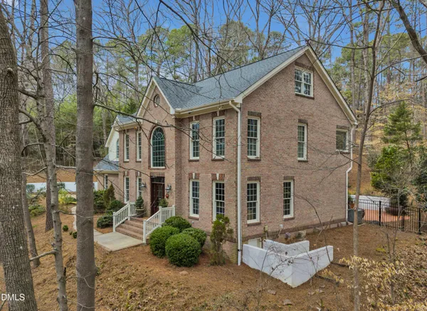 a view of a big house with a yard and lawn chairs