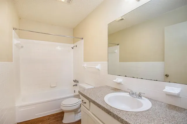 a bathroom with a sink toilet a mirror and shower