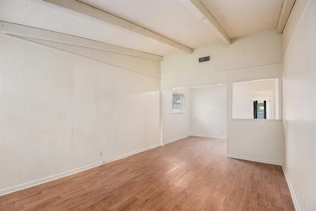 a view of empty room with wooden floor