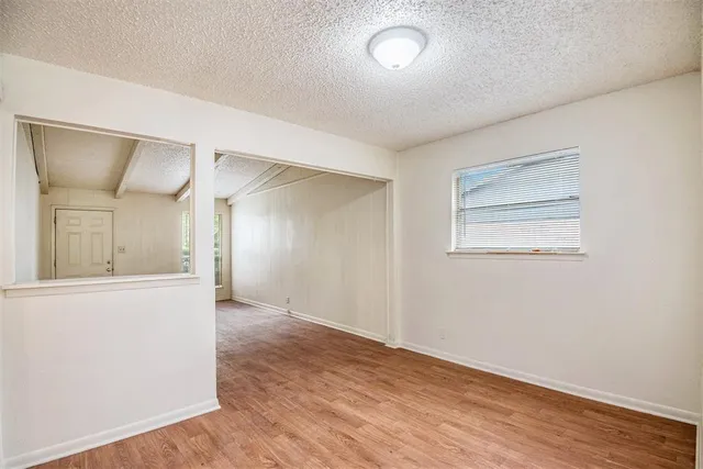 an empty room with wooden floor and mirror