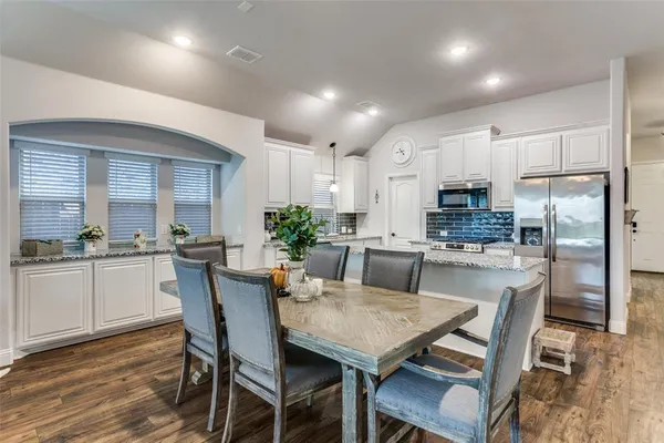 a kitchen with kitchen island a table and chairs in it