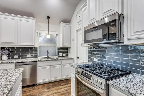 a kitchen with stainless steel appliances a stove sink and cabinets