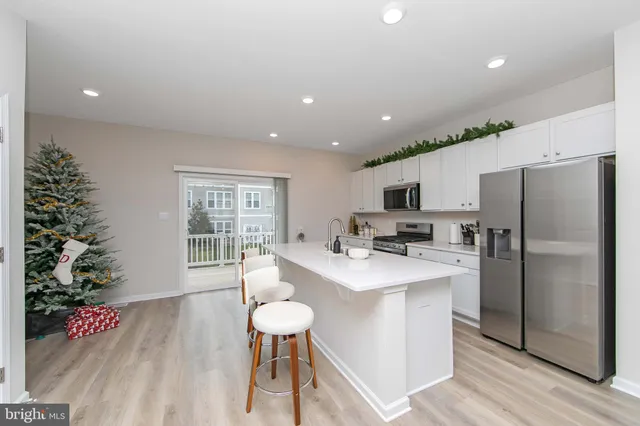 a kitchen with granite countertop a sink appliances cabinets and wooden floor