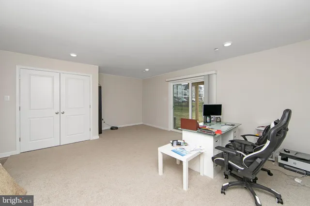 a view of a workspace with furniture and a window