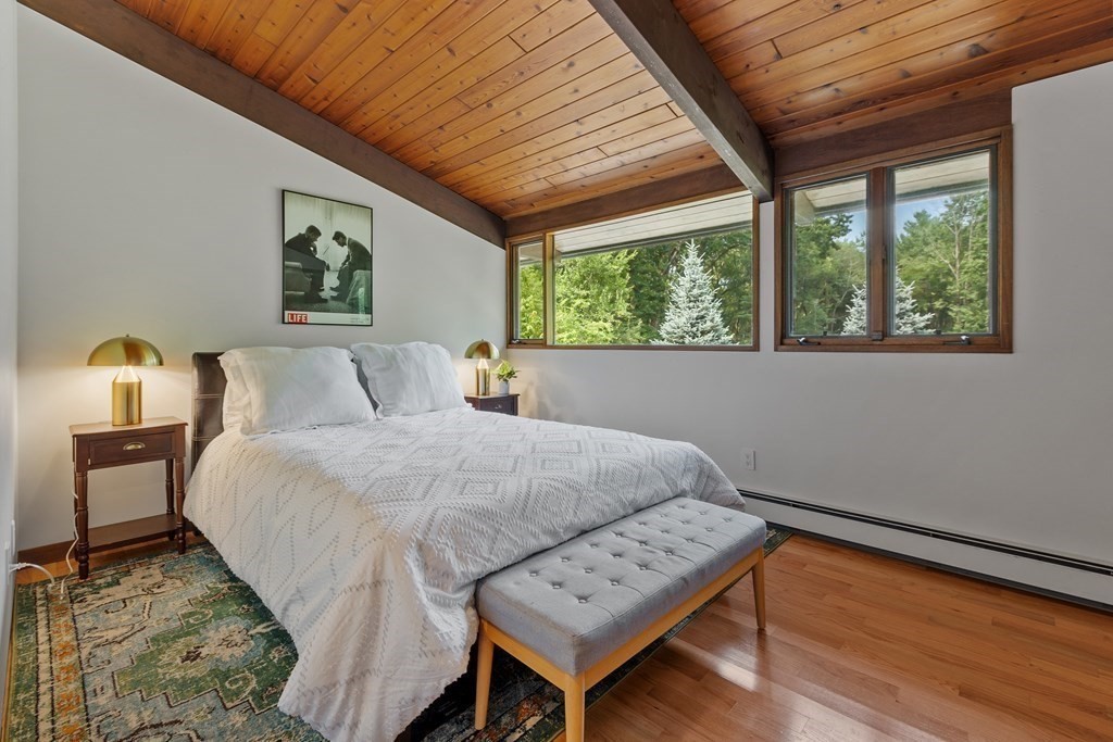 237 Stoney Gate Carlisle, MA 01741 - Photo 22 of 35 a bedroom with a bed a window and couch