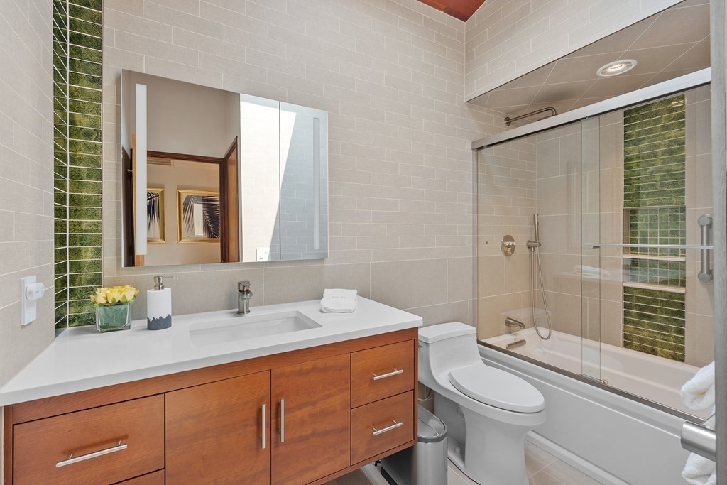 237 Stoney Gate Carlisle, MA 01741 - Photo 24 of 35 a bathroom with a sink a toilet a mirror and shower