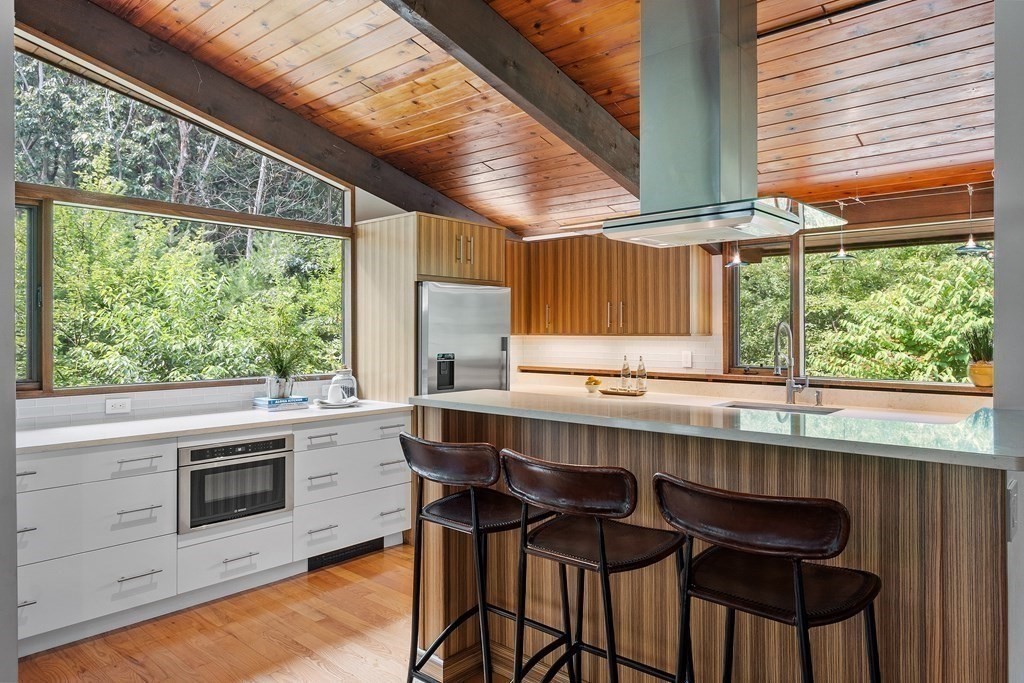 237 Stoney Gate Carlisle, MA 01741 - Photo 10 of 35 a kitchen with a stove a sink and chairs
