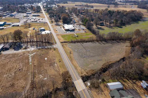 an aerial view of residential houses with outdoor space and trees all around