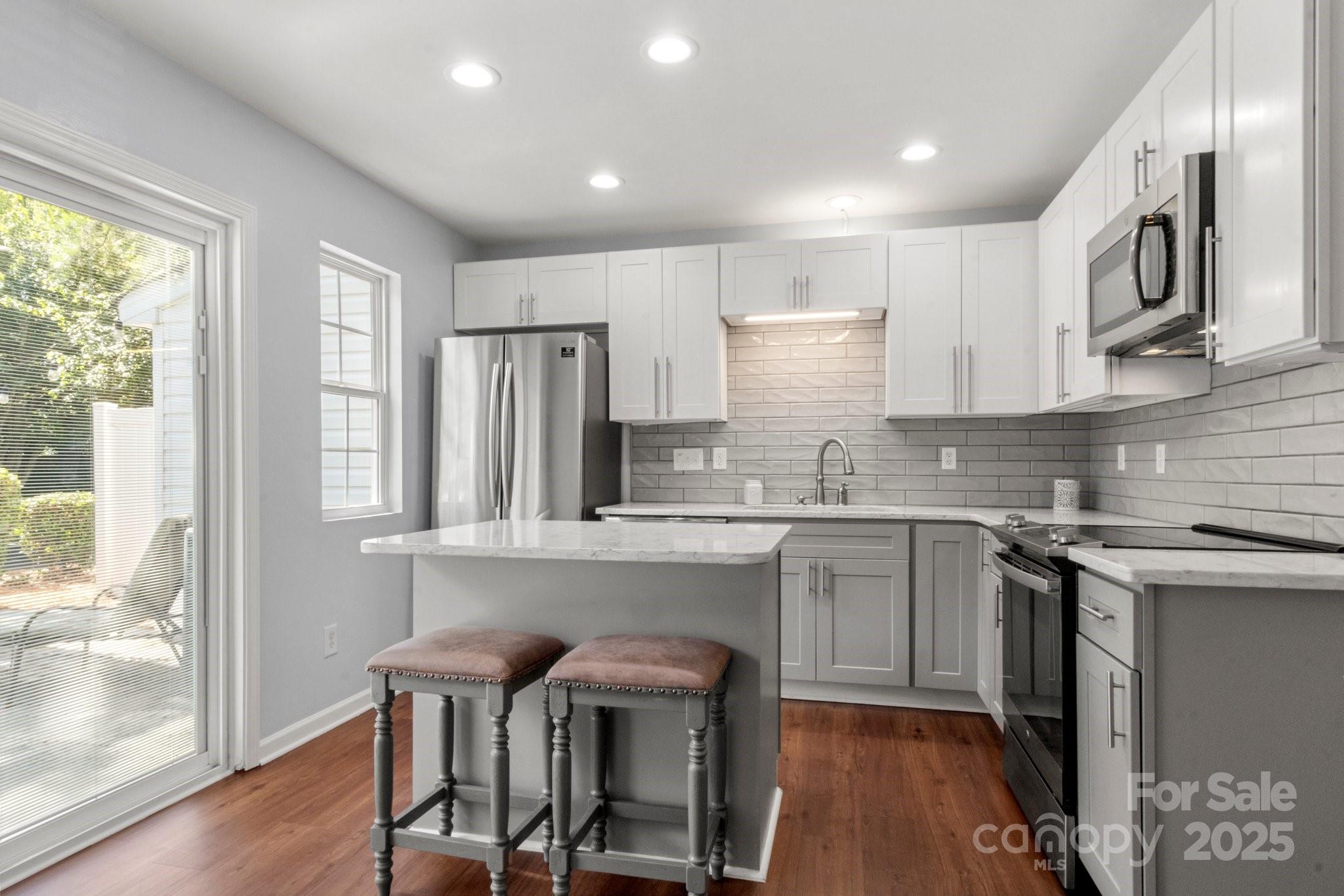 11023 Kinston Ridge Place Charlotte, NC 28273 - Photo 6 of 25 a kitchen with refrigerator a sink and chairs