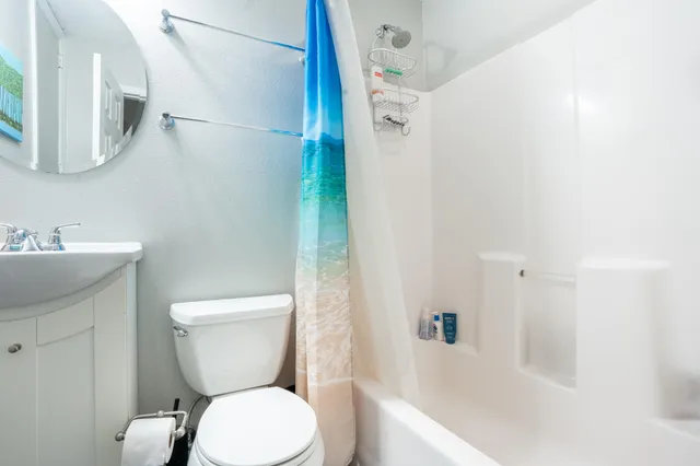 a white toilet sitting next to a bath tub