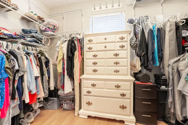 a view of walk in closet with clothes and shoes