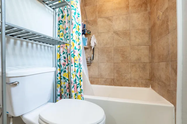 a bathroom with a sink a toilet and a shower curtain