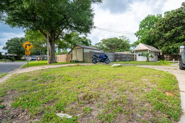 a view of a house with a big yard and large trees