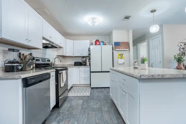 a kitchen with granite countertop a sink and cabinets