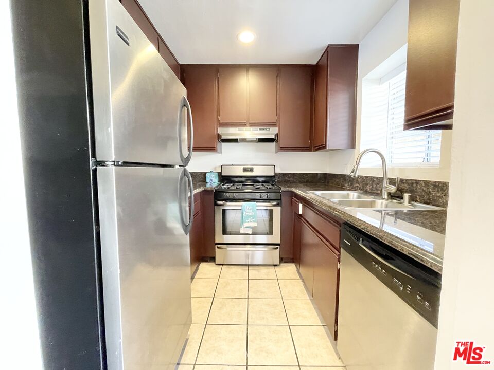 8722 Burton Way, Unit 102 Los Angeles, CA 90048 - Photo 2 of 11 a kitchen with stainless steel appliances granite countertop a stove a refrigerator and a sink