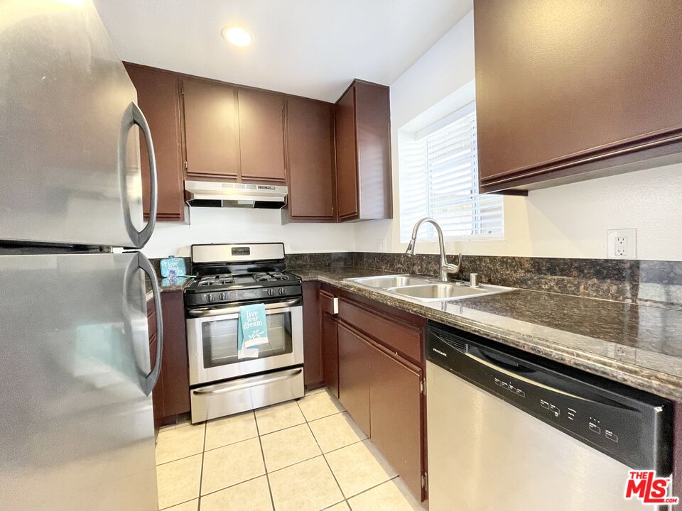 8722 Burton Way, Unit 102 Los Angeles, CA 90048 - Photo 3 of 11 a kitchen with stainless steel appliances granite countertop a sink stove and refrigerator