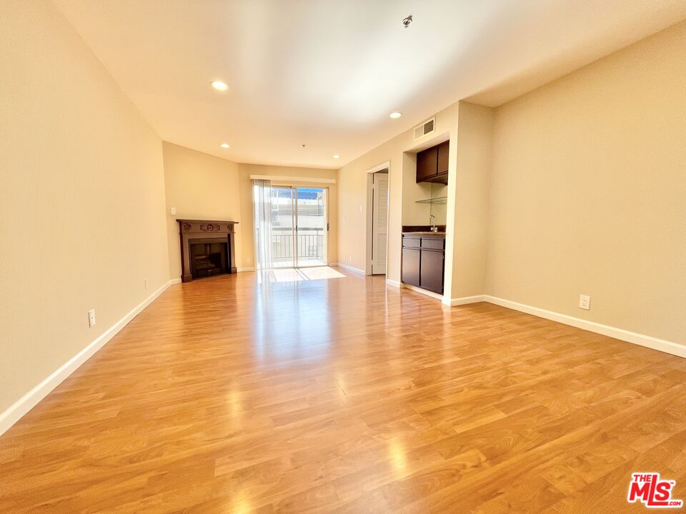 8722 Burton Way, Unit 102 Los Angeles, CA 90048 - Photo 5 of 11 a view of an empty room with wooden floor and a window