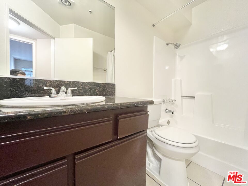 8722 Burton Way, Unit 102 Los Angeles, CA 90048 - Photo 9 of 11 a bathroom with a granite countertop sink toilet and shower