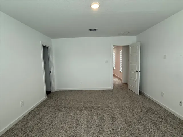 a bed sitting in a bedroom next to a cabinet and a book shelf
