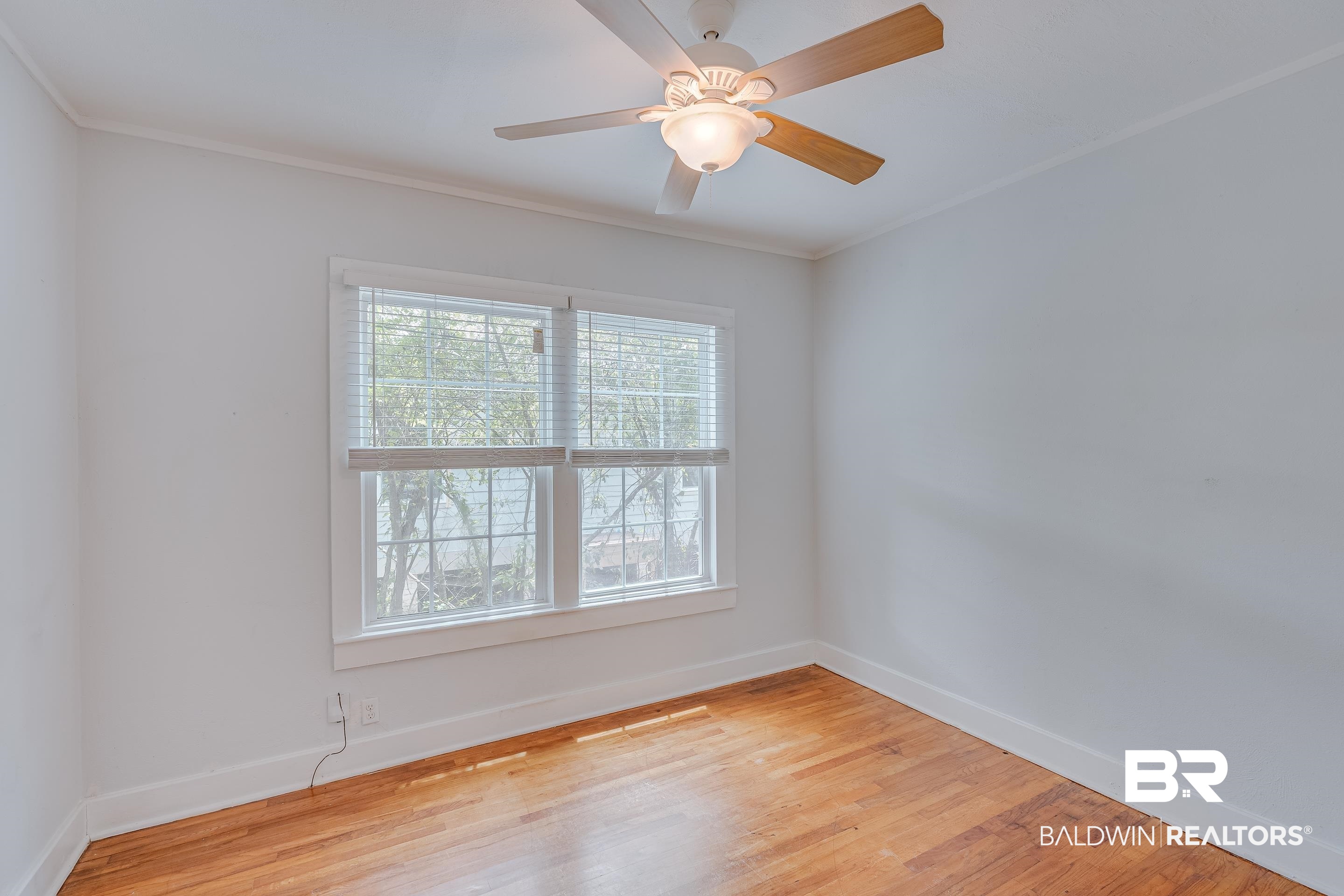 1852 Old Shell Road Mobile, AL 36607 - Photo 16 of 26 Unfurnished room featuring light wood finished floors, crown molding, and ceiling fan