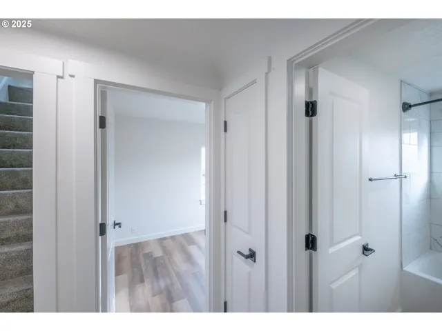 a view of an empty room with wooden floor and windows