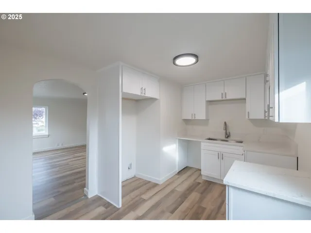 a kitchen with cabinets and wooden floor