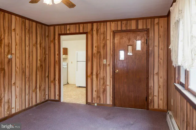 an empty room with windows it and front door