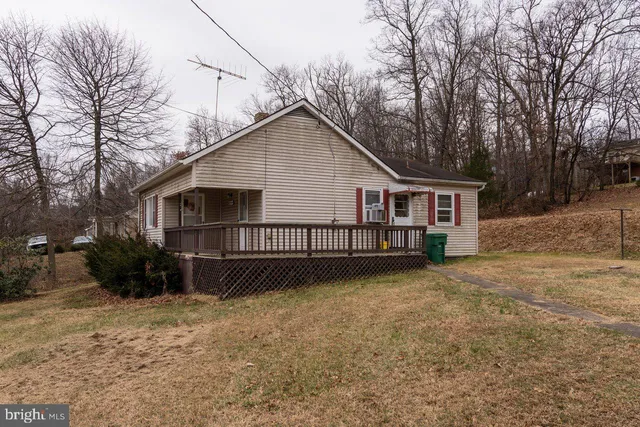 a view of a house with backyard and trees