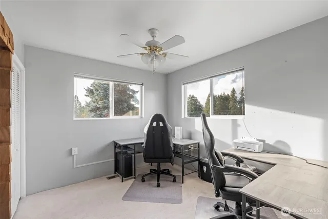 a view of a workspace with furniture and a window