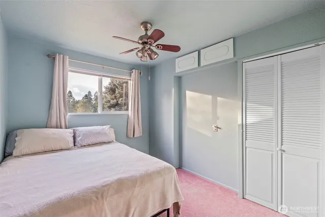 a bedroom with a large bed and a window