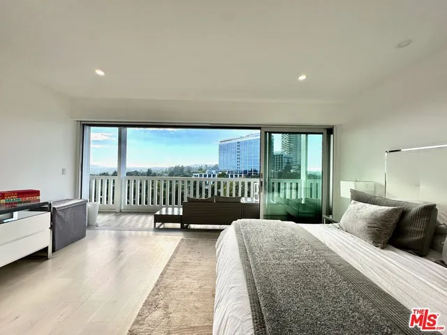 a bed sitting in a bedroom next to a balcony