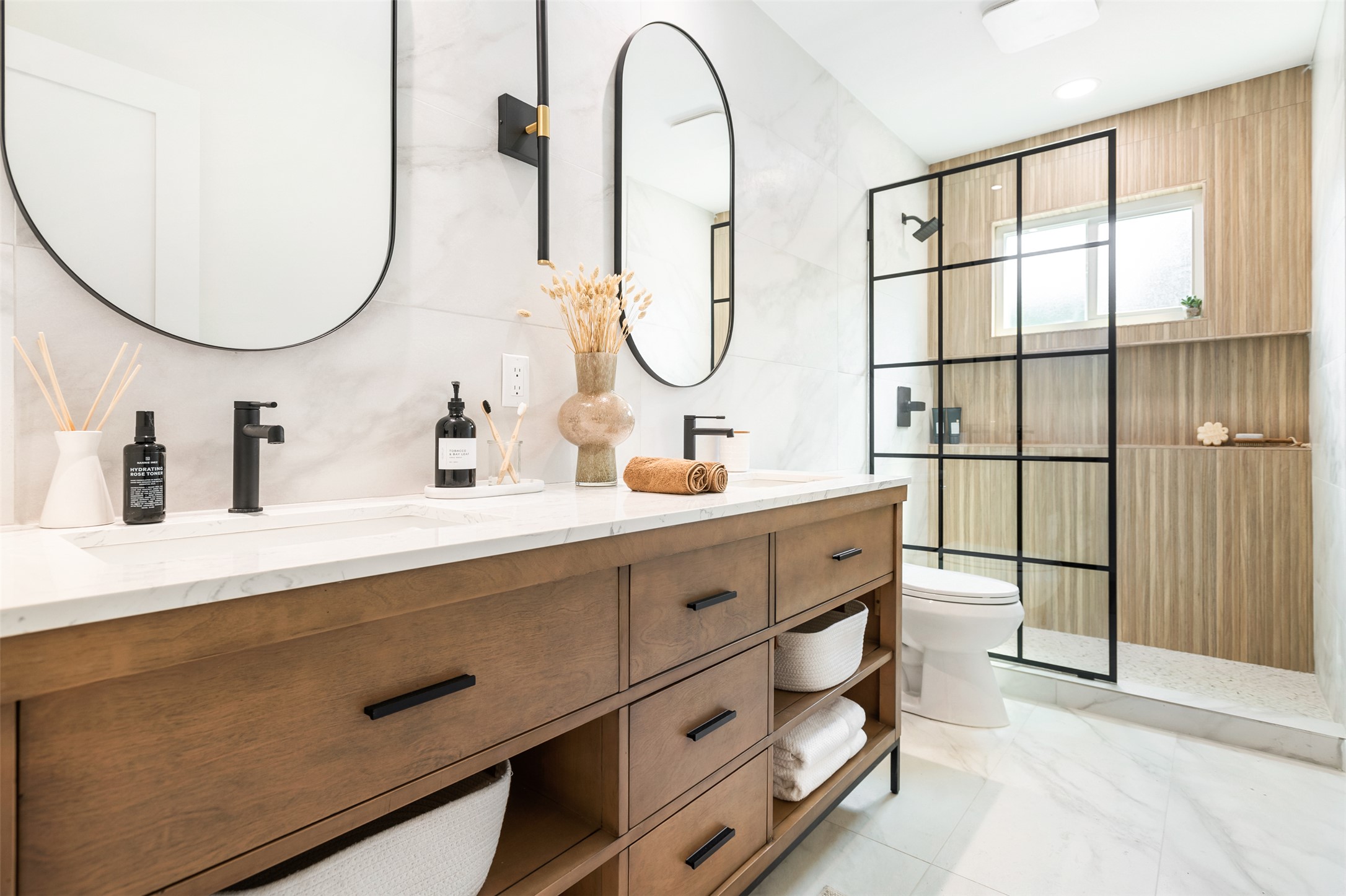 7604 Islander Drive Austin, TX 78749 - Photo 29 of 38 A well-appointed bathroom offers dual vanities, marble countertops, and a striking glass-enclosed shower.