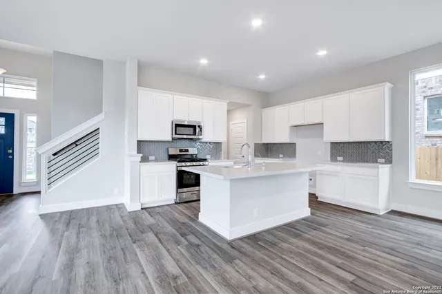a kitchen with white cabinets and stainless steel appliances