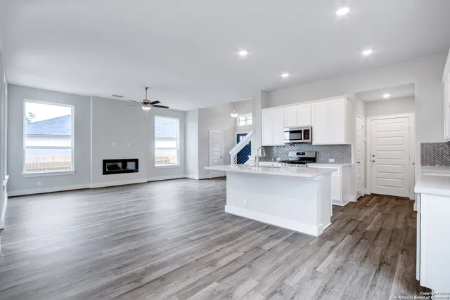 a kitchen with wooden floors and white cabinets