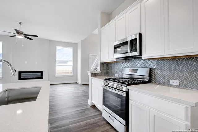 a kitchen with stainless steel appliances a stove a microwave and cabinets