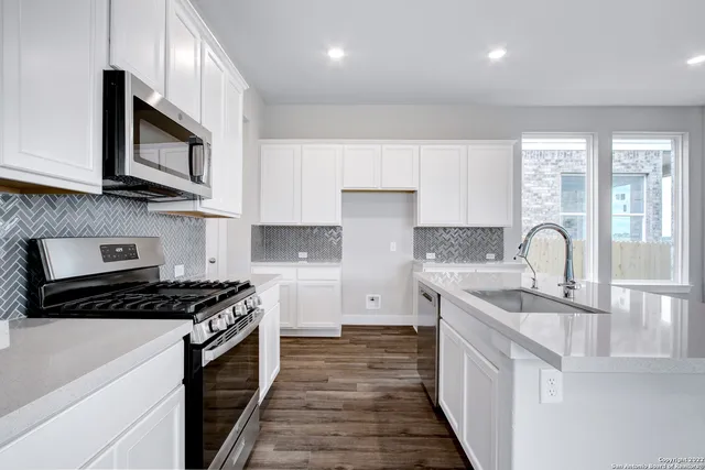 a kitchen with stainless steel appliances granite countertop a stove and a sink