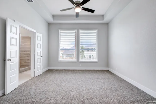an empty room with windows and fan