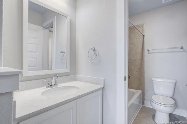 a bathroom with a granite countertop sink a mirror and a bathtub